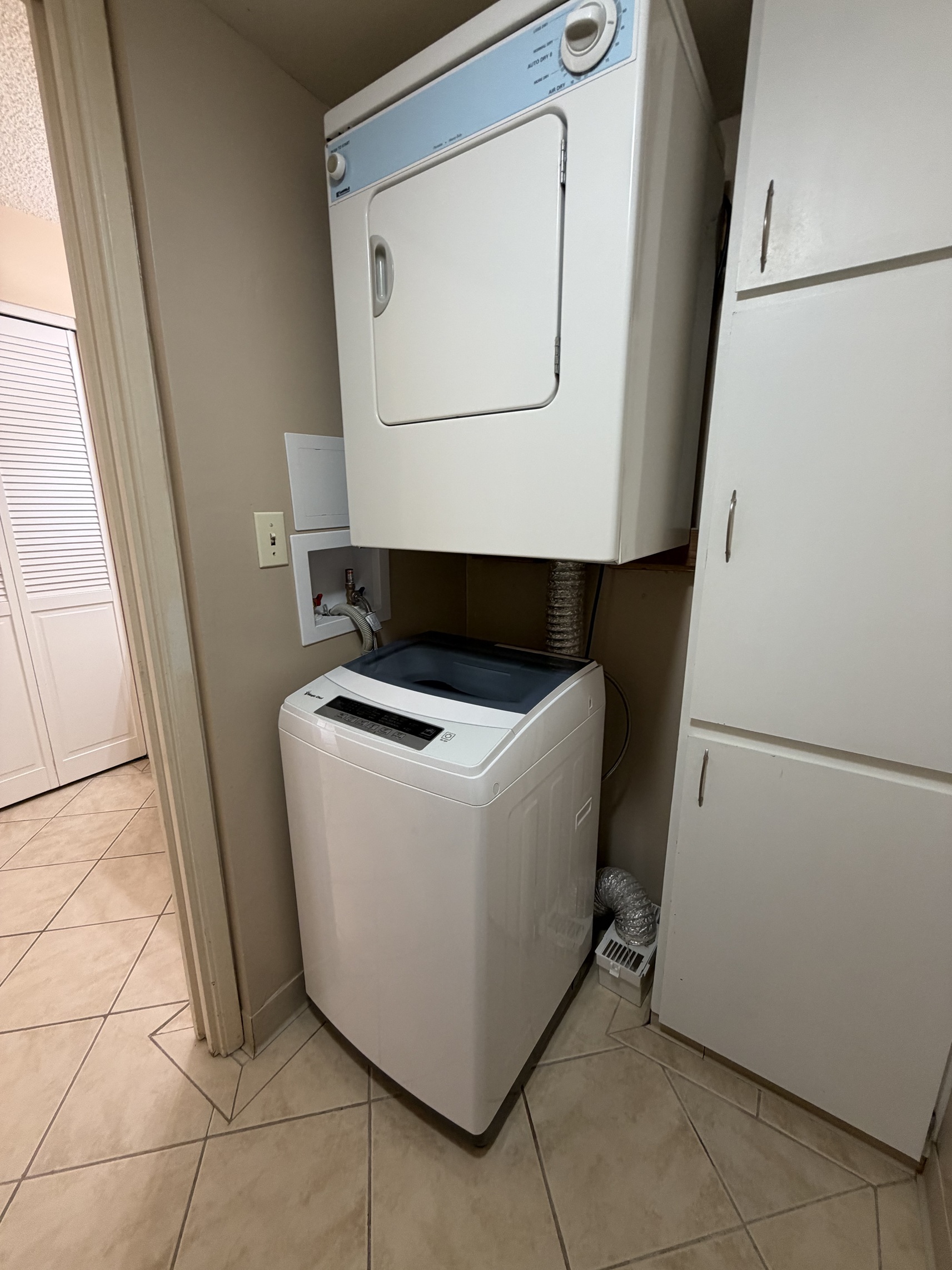 A white washing machine is in a small room.